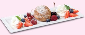 Tichy-Eismarillenknödel mit Staubzucker, Schlagobers, Erdbeeren, Kirsche und Beeren auf einem weißen Teller